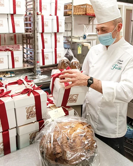 Confeiteiro embalando panetones para as encomendas
